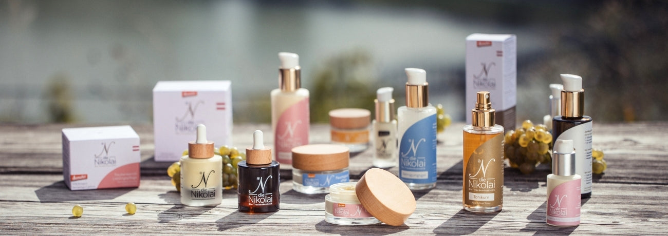 Komplettes dieNikolai Sortiment mit Serum, Lieblingspflege, Tonikum und Fluid-Duo auf Holzsteg am Donauufer – Demeter Bio-Traubenkosmetik aus der Wachau
