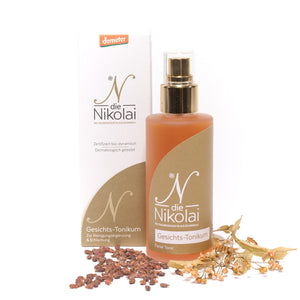 dieNikolai Gesichts-Tonikum Flakon mit Verpackung sowie Traubenkernen und getrockneten Lindenblüten – Demeter Bio-Traubenkosmetik aus Österreich