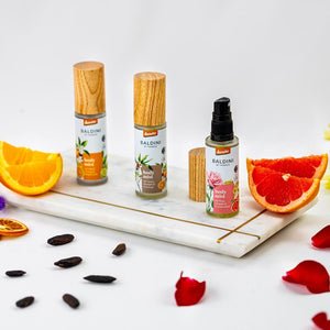 Drei Baldini by Taoasis Body Mist Sprays auf Marmortablett mit Zitrus- und Rosenakzenten – Demeter Bio-Körpersprays im dieNikolai Sortiment