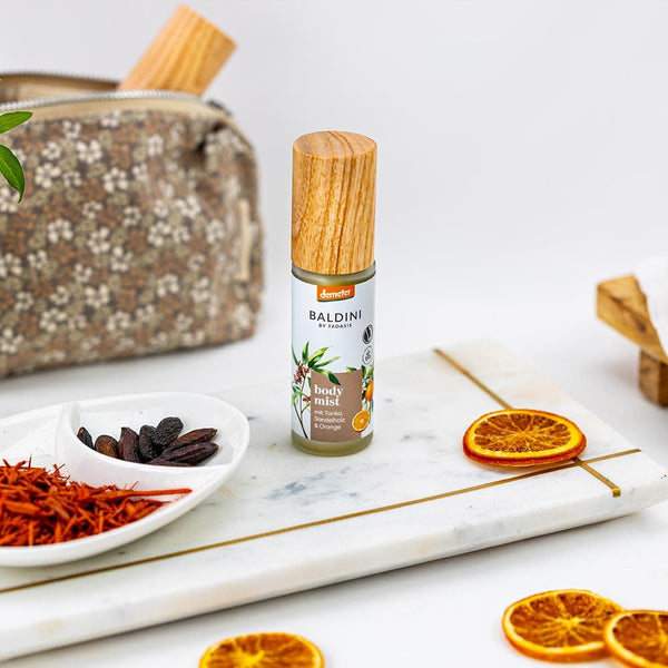 Baldini by Taoasis Body Mist Sandel Mood mit Tonka und Orange auf Marmorbrett mit Kulturbeutel und Safran – Bio-Körperspray erhältlich bei dieNikolai