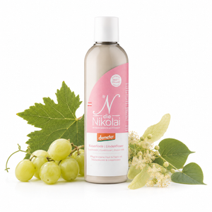 dieNikolai Bio-Traubenkosmetik Kaiserlinde Duschmilch, Conditioner und Shower Milk auf weißem Hintergrund, dezent dekoriert mit weißen Weintrauben, Weinblättern, Lindenblüten und Lindenblättern.