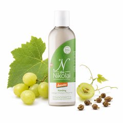 dieNikolai Bio-Traubenkosmetik Riesling Duschgel, Shampoo und Shower Gel auf weißem Hintergrund, dezent dekoriert mit weißen Weintrauben, Weinblättern und Traubenkernen.
